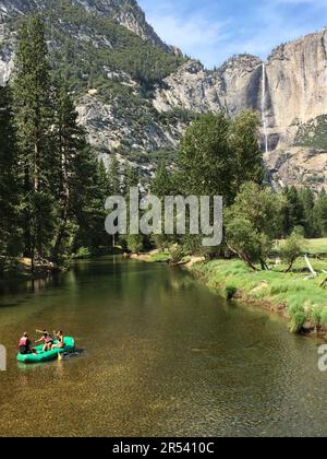 Un groupe de personnes apprécient une aventure en radeau relaxante sur la Merced River, en vue des chutes de Yosemite, dans le parc national de Yosemite Banque D'Images