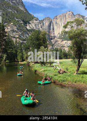 Les gens et les familles apprécient une journée de vacances d'été en rafting sur la rivière Merced dans la vallée du parc national de Yosemite Banque D'Images