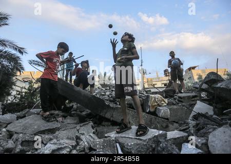 Gaza, Palestine. 31st mai 2023. Des enfants palestiniens ont vu jouer dans les décombres de leurs bâtiments résidentiels détruits après les frappes israéliennes sur la ville de Gaza. Israël et le mouvement du Jihad islamique ont accepté une trêve négociée par l'Égypte à la fin du mois de mai. Israël a mené plusieurs attaques contre les dirigeants militaires du mouvement palestinien du Jihad islamique en réponse aux tirs de roquettes vers Israël depuis la bande de Gaza. Les effets des raids israéliens sur la ville de Gaza sur 12 mai 2023. Crédit : SOPA Images Limited/Alamy Live News Banque D'Images