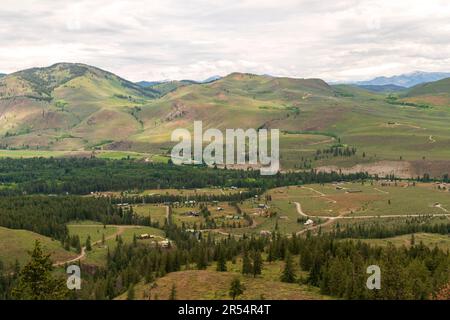 Une communauté de maisons et de lots non développés se trouve à la base des contreforts de North Cascades, dans la vallée de la Methow, près de Winthrop, Washington, États-Unis. Banque D'Images