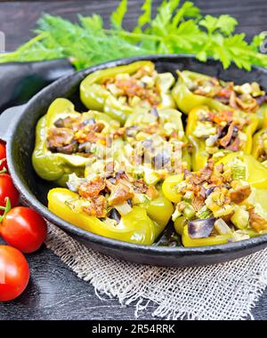 Poivre sucré farci de champignons, tomates, courgettes, aubergines et oignons, assaisonnés de vin, ail, thym et épices dans une poêle sur sackclot Banque D'Images