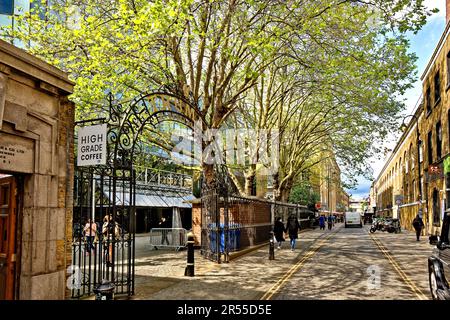 London Brick Lane Tower Hamlets Truman porte en fer forgé et arbres avec des feuilles au printemps Banque D'Images