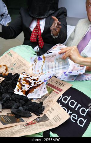 Londres, Angleterre, Royaume-Uni 01/06/2023 les activistes Money Rebellion présentent un « trois ans » satirique chez Standard Chartered entre le PDG Bill Winters et ses amis des combustibles fossiles, le pétrole et le charbon, comme Rishi Sunak cherche à servir du champagne et à se voir offrir occasionnellement un bung d'argent. Banque D'Images