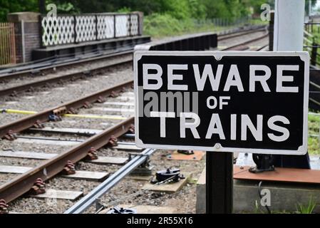 Attention au panneau de trains à côté d'un passage à pied à la gare de Broadway sur le train à vapeur Gloucestershire Warwickshire. Banque D'Images