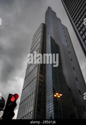 Londres, Royaume-Uni : The Heron Tower ou Salesforce Tower au 110 Bishopsgate sur fond de nuages sombres. Un feu rouge indique un arrêt. Banque D'Images