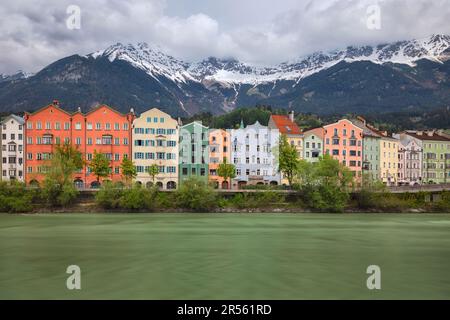 Innsbruck, Autriche - maisons colorées sur le remblai de la rivière Inn avec des montagnes enneigées en arrière-plan Banque D'Images