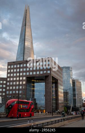 Londres, Royaume-Uni: Le bâtiment de bureaux carrés du pont n° 1 de Londres avec le Shard derrière. Vue depuis le London Bridge avec un bus rouge de Londres. Vue en soirée. Banque D'Images