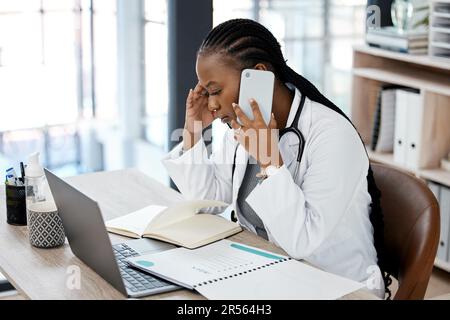 Hôpital, médecin et femme noire avec le stress sur un appel téléphonique pour la conversation, la conversation et la discussion. Soins de santé, épuisement professionnel et femme Banque D'Images