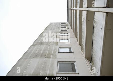 Façade d'un ancien immeuble en hauteur en béton avec balcons et fenêtres, vue d'en dessous, ciel gris, concept immobilier et immobilier, co Banque D'Images