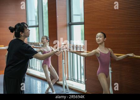 SHENYANG, 1 juin 2023 (Xinhua) -- Un professeur instruit des élèves dans une école de ballet affiliée au Ballet de Liaoning à Shenyang, dans la province de Liaoning, au nord-est de la Chine, au 31 mai 2023. Fondée en 1994, l'école de ballet affiliée à Liaoning Ballet est une importante base de formation professionnelle de ballet en Chine. L'école recrute des enfants âgés de 10 à 12 ans qui s'intéressent au ballet et qui ont un certain niveau de compétence en ballet de partout au pays. Près de 1 000 enfants font une demande d'école chaque année, et environ 70 d'entre eux sont acceptés. À l'heure actuelle, plus de 400 étudiants étudient Banque D'Images