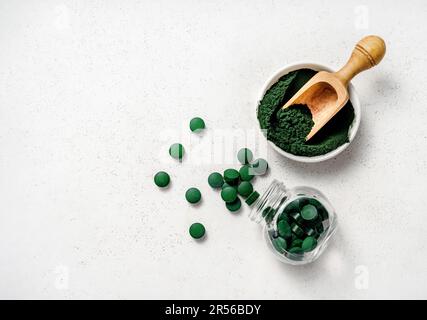 Spiruline algues poudre et Spiruline comprimés sur fond blanc. Banque D'Images