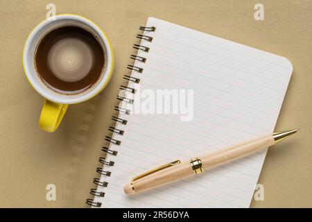 carnet à croquis en spirale vierge sur papier texturé avec une tasse de café, plat de bureau Banque D'Images