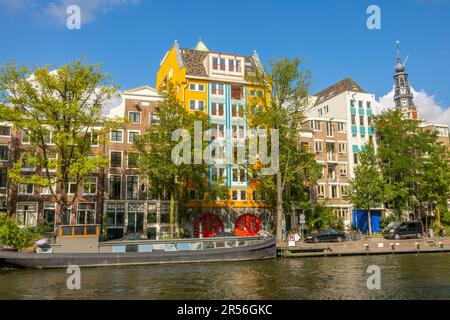 Pays-Bas. Journée d'été ensoleillée sur le canal d'Amsterdam. Façades de bâtiments néerlandais typiques et barge résidentielle à la jetée Banque D'Images