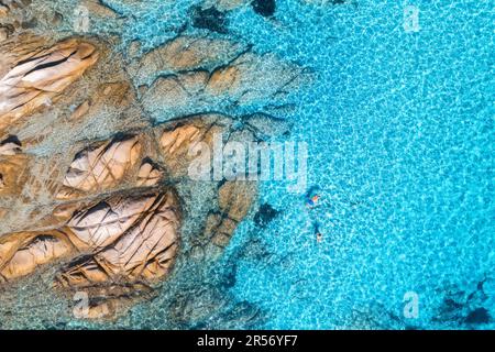 Vue aérienne des personnes nageant dans la mer bleue, plage rocheuse, vagues Banque D'Images
