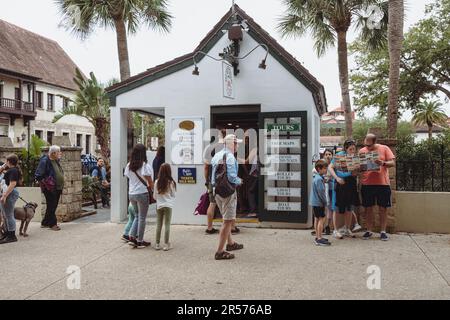 St. Augustine, Floride - 31 décembre 2022: Les touristes s'attardent autour de la vieille ville informations sur le tramway visiteurs stand, regardant et lisant des cartes du lo Banque D'Images