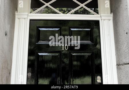 Porte avant en panneau de bois peint en noir avec le numéro 10 et cadre de porte en bois blanc. Banque D'Images