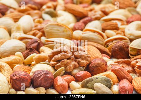 Différents types de noix et de graines, photo avec mise au point sélective. Noix pelées, noisettes, arachides pelées, noix de pin, graines d'amande, graines de cajou, Banque D'Images