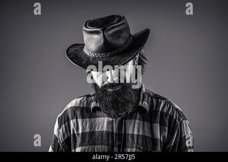 Portrait homme portant chapeau de cow-boy. Cowboys en chapeau. Jolie macho barbu. Cow-boys non rasés. Noir et blanc. Cow-boy américain. Chapeau de cowboy en cuir Banque D'Images