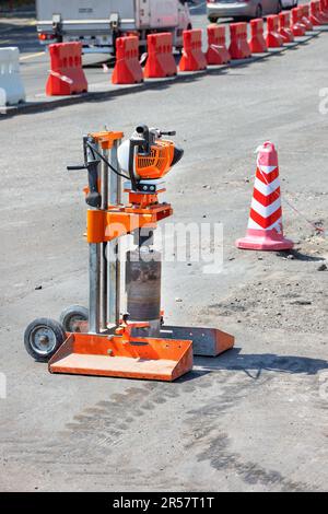 Forer une machine à essence pour couper des échantillons de béton bitumineux sur le fond de la réparation de routes. Banque D'Images