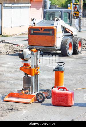 Forer une machine à essence pour couper des échantillons de béton bitumineux avec une cartouche de carburant sur le fond de la machinerie routière. Banque D'Images