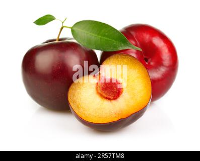 Prunes mûres fruits avec des tranches isolées sur fond blanc Banque D'Images