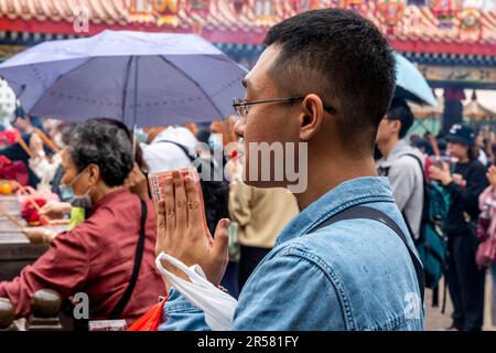 Les jeunes Chinois adorant le Temple Wong Tai Sin, Hong Kong, Chine. Banque D'Images