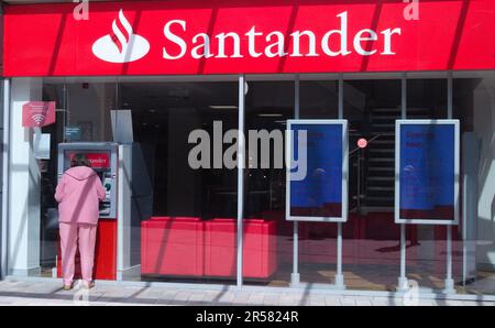 Une femme utilise un guichet automatique à la banque Santander à Stockport, dans le Grand Manchester Banque D'Images