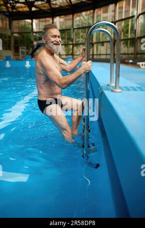 Souriant, joyeux homme de natation, les boxers sortent de la piscine Banque D'Images