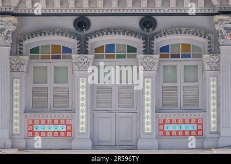 Extérieur traditionnel de la maison d'achats Peranakan avec volets en bois gris, carreaux fleuris et colonnes en plâtre très décoratives Banque D'Images