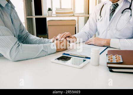 Le médecin a serré les mains et consolé les patients qui s'inquiétaient du traitement. Banque D'Images