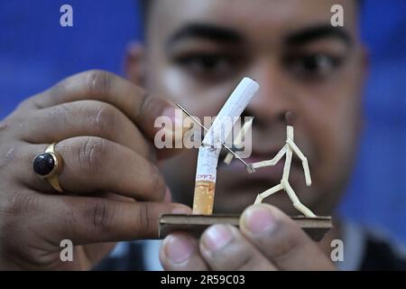 Bijoy Debnath, un artiste de 21 ans qui présente son œuvre d'art créée avec des allumettes et des cigarettes représentant un homme de allumettes tuant une cigarette avec une épée dans le cadre d'une campagne « cesser de fumer » à la veille de la « Journée mondiale sans tabac ». 31 mai est célébrée comme la Journée mondiale sans tabac pour sensibiliser à la consommation de tabac dans le monde entier. Agartala, Inde. Banque D'Images