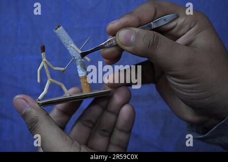 Bijoy Debnath, un artiste de 21 ans qui présente son œuvre d'art créée avec des allumettes et des cigarettes représentant un homme de allumettes tuant une cigarette avec une épée dans le cadre d'une campagne « cesser de fumer » à la veille de la « Journée mondiale sans tabac ». 31 mai est célébrée comme la Journée mondiale sans tabac pour sensibiliser à la consommation de tabac dans le monde entier. Agartala, Inde. Banque D'Images