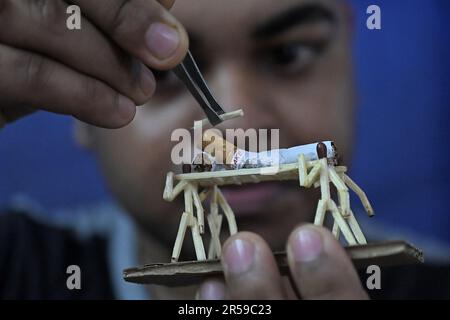 Bijoy Debnath, un artiste de 21 ans qui présente son œuvre d'art créée avec des allumettes et des cigarettes représentant un homme de allumettes tuant une cigarette avec une épée dans le cadre d'une campagne « cesser de fumer » à la veille de la « Journée mondiale sans tabac ». 31 mai est célébrée comme la Journée mondiale sans tabac pour sensibiliser à la consommation de tabac dans le monde entier. Agartala, Inde. Banque D'Images