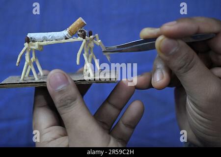 Bijoy Debnath, un artiste de 21 ans qui présente son œuvre d'art créée avec des allumettes et des cigarettes représentant un homme de allumettes tuant une cigarette avec une épée dans le cadre d'une campagne « cesser de fumer » à la veille de la « Journée mondiale sans tabac ». 31 mai est célébrée comme la Journée mondiale sans tabac pour sensibiliser à la consommation de tabac dans le monde entier. Agartala, Inde. Banque D'Images