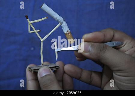 Bijoy Debnath, un artiste de 21 ans qui présente son œuvre d'art créée avec des allumettes et des cigarettes représentant un homme de allumettes tuant une cigarette avec une épée dans le cadre d'une campagne « cesser de fumer » à la veille de la « Journée mondiale sans tabac ». 31 mai est célébrée comme la Journée mondiale sans tabac pour sensibiliser à la consommation de tabac dans le monde entier. Agartala, Inde. Banque D'Images