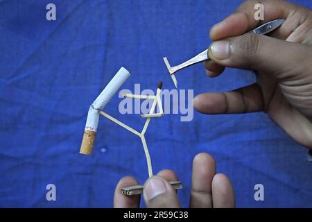 Bijoy Debnath, un artiste de 21 ans qui présente son œuvre d'art créée avec des allumettes et des cigarettes représentant un homme de allumettes tuant une cigarette avec une épée dans le cadre d'une campagne « cesser de fumer » à la veille de la « Journée mondiale sans tabac ». 31 mai est célébrée comme la Journée mondiale sans tabac pour sensibiliser à la consommation de tabac dans le monde entier. Agartala, Inde. Banque D'Images