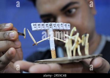 Bijoy Debnath, un artiste de 21 ans qui présente son œuvre d'art créée avec des allumettes et des cigarettes représentant un homme de allumettes tuant une cigarette avec une épée dans le cadre d'une campagne « cesser de fumer » à la veille de la « Journée mondiale sans tabac ». 31 mai est célébrée comme la Journée mondiale sans tabac pour sensibiliser à la consommation de tabac dans le monde entier. Agartala, Inde. Banque D'Images