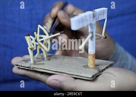 Bijoy Debnath, un artiste de 21 ans qui présente son œuvre d'art créée avec des allumettes et des cigarettes représentant un homme de allumettes tuant une cigarette avec une épée dans le cadre d'une campagne « cesser de fumer » à la veille de la « Journée mondiale sans tabac ». 31 mai est célébrée comme la Journée mondiale sans tabac pour sensibiliser à la consommation de tabac dans le monde entier. Agartala, Inde. Banque D'Images