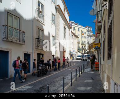 Un crocodile de touristes suivant un guide dans le quartier Alfama de Lisbonne Banque D'Images