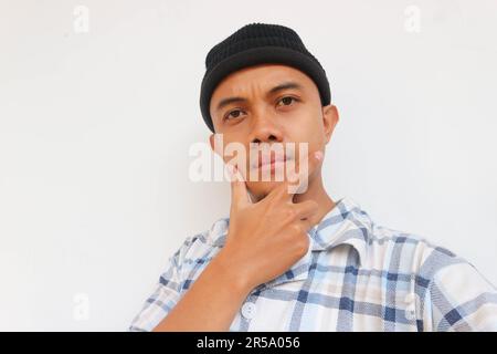 Homme portant un pyjama et un bonnet beanie souriant en regardant l'appareil photo. Isolé sur fond blanc Banque D'Images