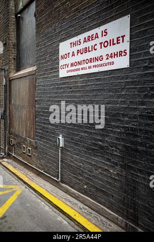 Ce n'est pas un panneau d'avertissement de toilettes publiques dans une allée de Londres. Signez un avertissement dans une allée contre l'urination et la surveillance CCTV. Banque D'Images