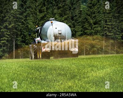 Un tracteur fertilisant un champ avec du fumier, Autriche Banque D'Images