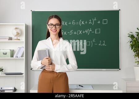 Portrait du jeune professeur de mathématiques près du tableau noir en classe Banque D'Images