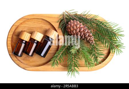 Plateau avec bouteilles d'huile essentielle de pin, branches et cône sur fond blanc, vue de dessus Banque D'Images