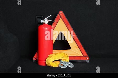 Extincteur rouge, sangle de remorquage et triangle d'avertissement d'urgence pliable dans le coffre. Sécurité automobile Banque D'Images