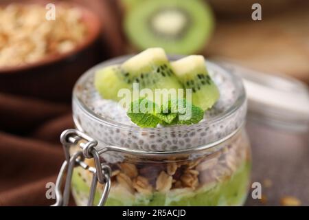 Délicieux dessert avec des graines de kiwi et de chia dans un pot en verre, en gros plan Banque D'Images