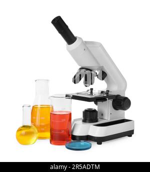 Verrerie de laboratoire avec liquides colorés et microscope isolé sur blanc Banque D'Images