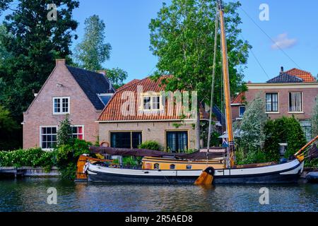 Weesp, pays-Bas - 05 juillet. 2022. Bateau à voile à craie amarré sur la rivière Vecht en face de maisons traditionnelles hollandaises. Banque D'Images