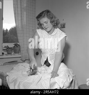 Repassage dans le 1950s. Une femme a vu repasser ses vêtements. Elle est actrice Sonja Stjernquist 1931-2002. Suède 1951. Conard réf. 1743 Banque D'Images