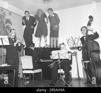 Dans le 1940s. Un groupe de quatre musiciens joue tandis que trois personnes sont debout sur le piano, se déplaçant visiblement vers la musique d'oscillation. Suède 1943. Kristoffersson réf. E23-2 Banque D'Images